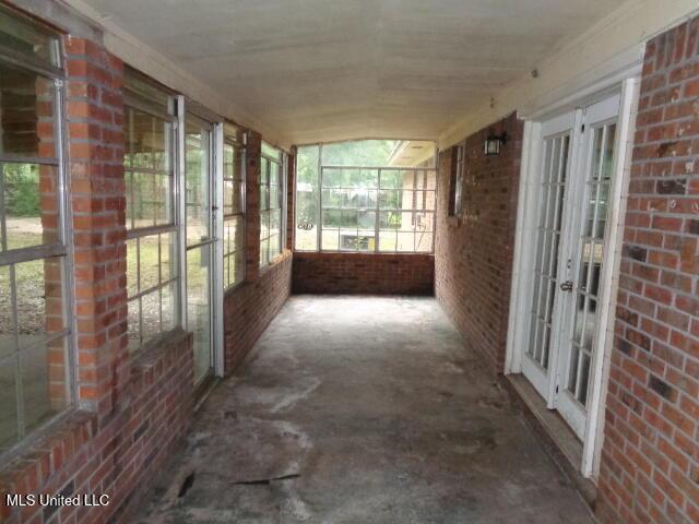 6301 Pioneer Trl, Moss Point, MS 39562 - unfurnished sunroom featuring french doors and brick wall