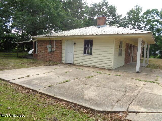 6301 Pioneer Trl, Moss Point, MS 39562 - rear view of house with a metal roof, a chimney, a patio, and brick siding