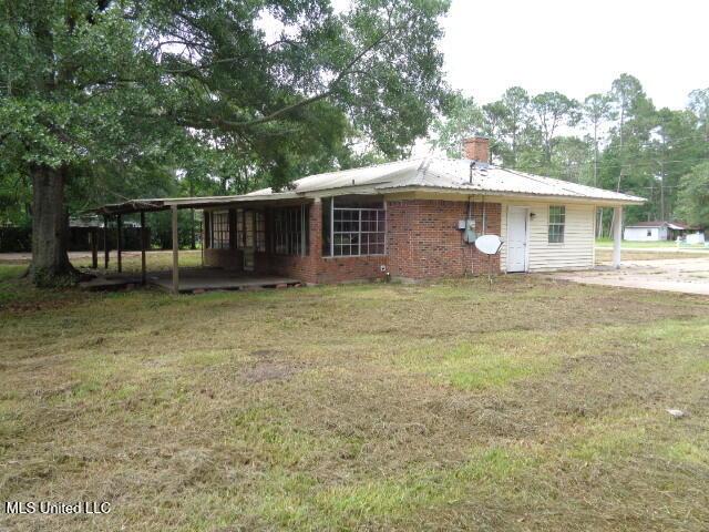 6301 Pioneer Trl, Moss Point, MS 39562 - view of front of home featuring a front lawn, a chimney, brick siding, and a metal roof