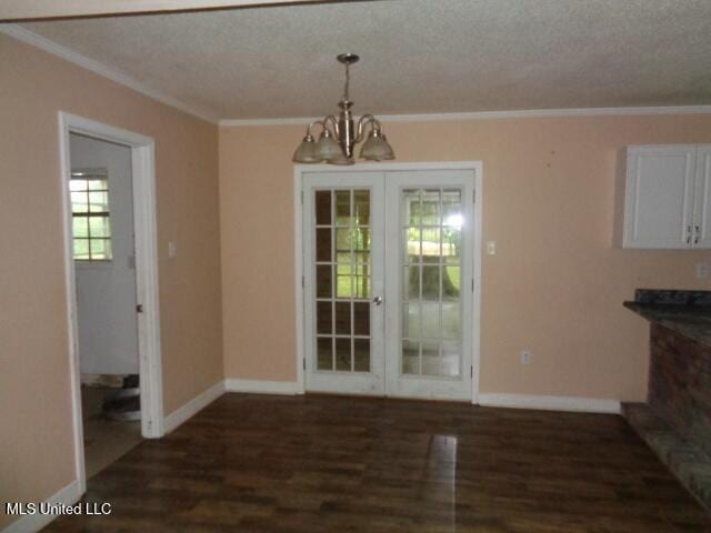 6301 Pioneer Trl, Moss Point, MS 39562 - unfurnished dining area with a chandelier, dark wood finished floors, ornamental molding, and a textured ceiling