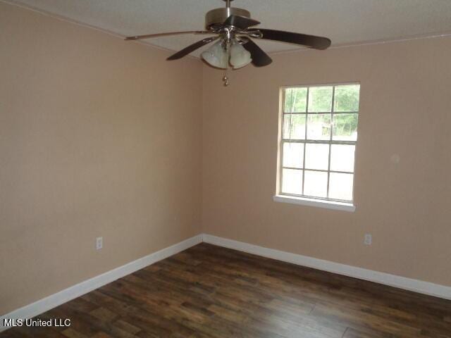 6301 Pioneer Trl, Moss Point, MS 39562 - empty room with dark wood-type flooring, a ceiling fan, and ornamental molding