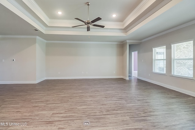 unfurnished room featuring a raised ceiling, crown molding, wood-type flooring, and ceiling fan