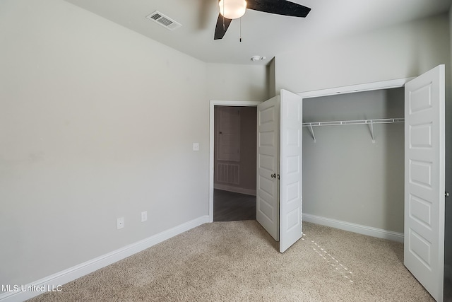 unfurnished bedroom featuring ceiling fan, light carpet, and a closet