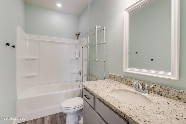 full bathroom with toilet, vanity, hardwood / wood-style floors, and tub / shower combination