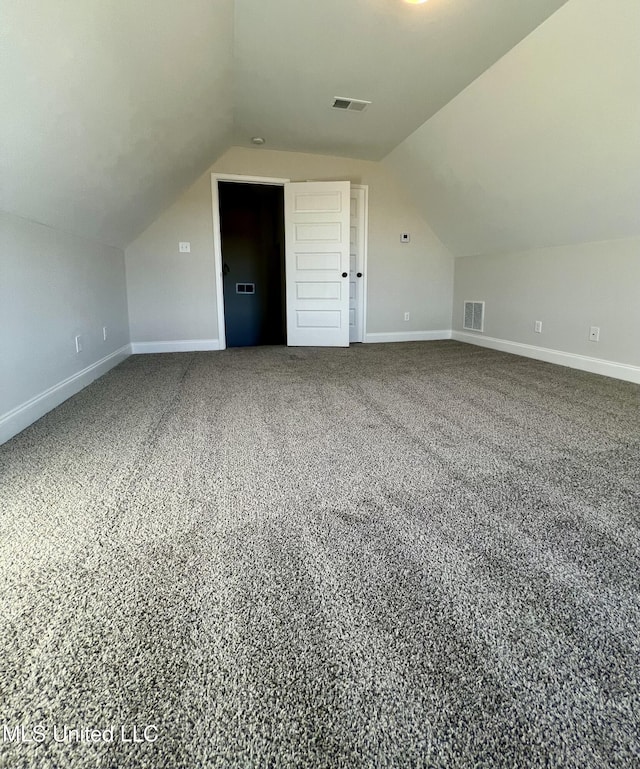 additional living space featuring vaulted ceiling and carpet floors