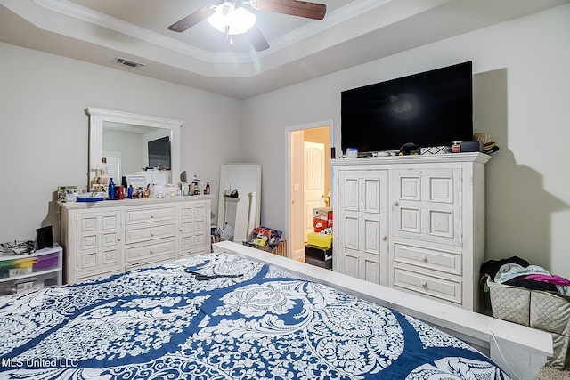 bedroom featuring a raised ceiling, ceiling fan, and ornamental molding