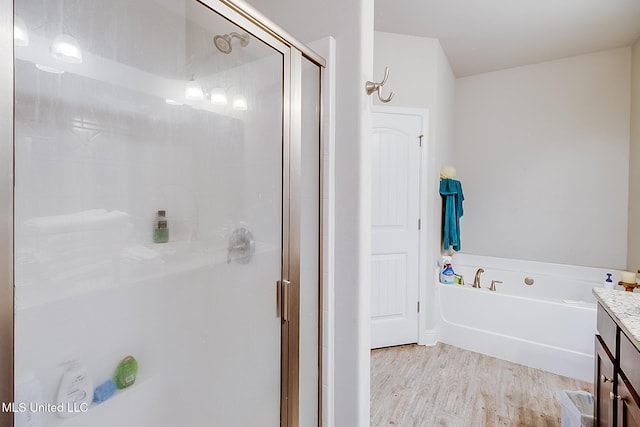 bathroom with vanity, hardwood / wood-style flooring, and separate shower and tub