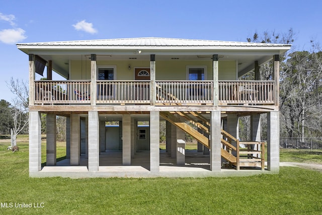 back of house featuring a yard, a patio, metal roof, and stairway