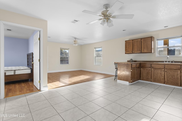 kitchen with a sink, visible vents, a wealth of natural light, and brown cabinetry