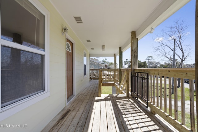 wooden terrace featuring visible vents