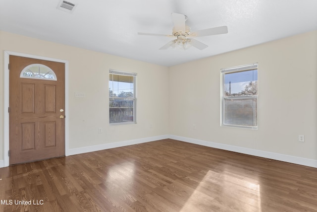 entryway featuring ceiling fan, visible vents, baseboards, and wood finished floors