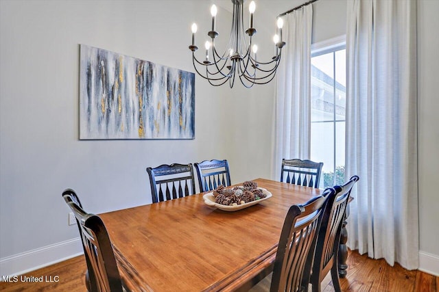 dining room with wood-type flooring and an inviting chandelier