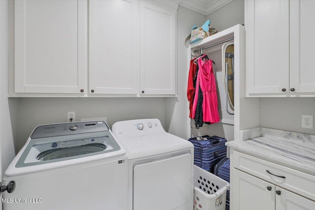 clothes washing area featuring washer and dryer, cabinets, and ornamental molding