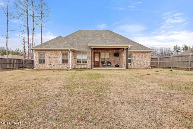 back of house featuring a patio area and a lawn