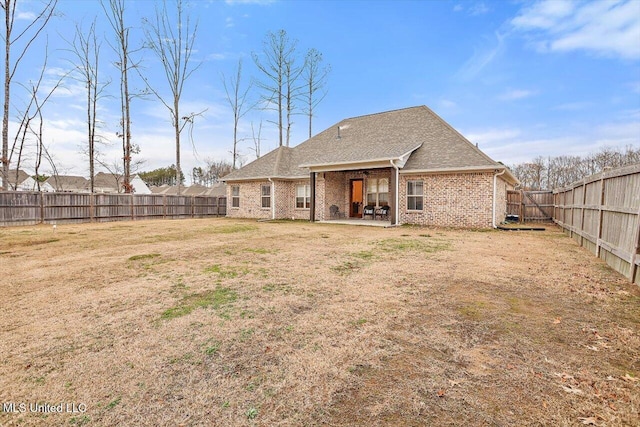 rear view of house with a patio area and a lawn