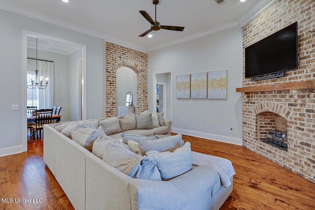 living room with hardwood / wood-style floors, ceiling fan with notable chandelier, and crown molding