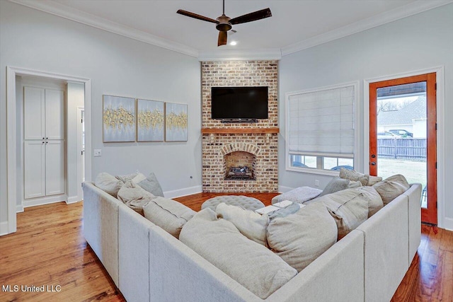 living room with a fireplace, light wood-type flooring, ceiling fan, and ornamental molding