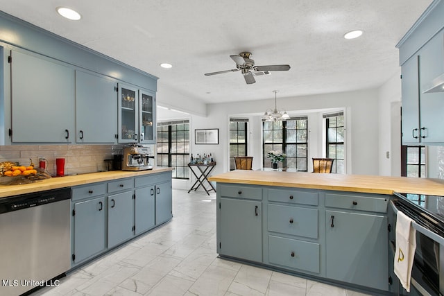 kitchen featuring dishwasher, wooden counters, decorative light fixtures, and plenty of natural light