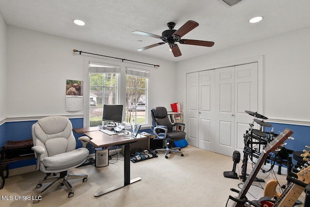 carpeted office with a textured ceiling and ceiling fan