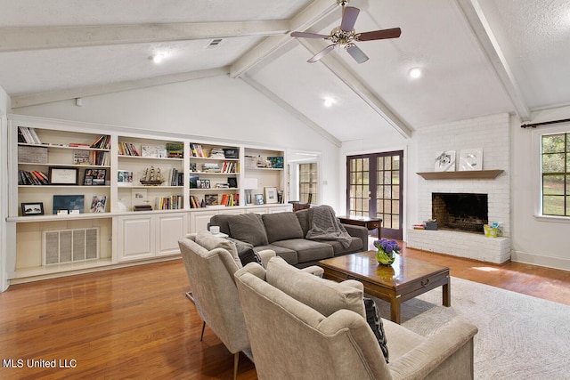 living room featuring light hardwood / wood-style floors, a textured ceiling, vaulted ceiling with beams, and ceiling fan