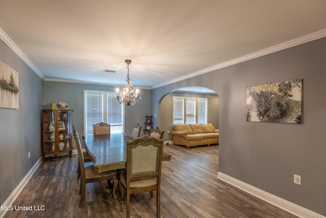 211 Traceway Dr, Natchez, MS 39120 - dining area featuring arched walkways, a chandelier, dark wood-style flooring, and crown molding