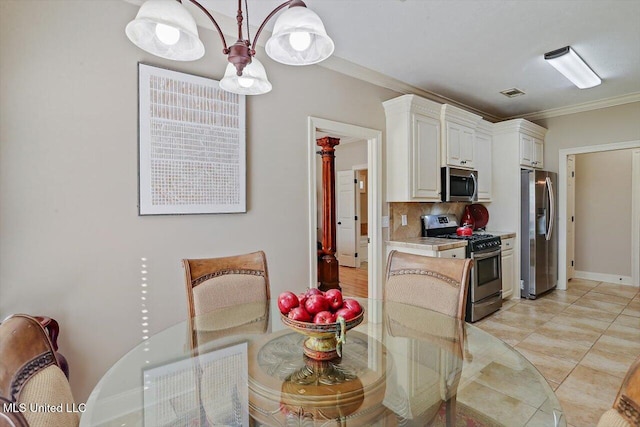 kitchen with decorative backsplash, appliances with stainless steel finishes, crown molding, light tile patterned floors, and white cabinetry