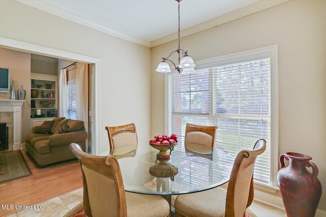 dining room featuring light wood-type flooring, ornamental molding, and an inviting chandelier