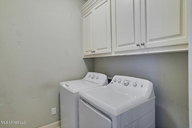 laundry area with washing machine and dryer and cabinets