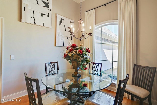 dining room featuring hardwood / wood-style floors and an inviting chandelier