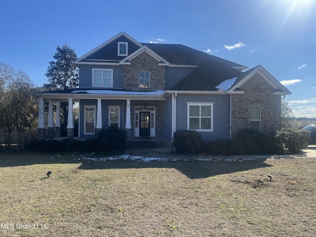 view of front facade featuring brick siding, board and batten siding, and a front yard