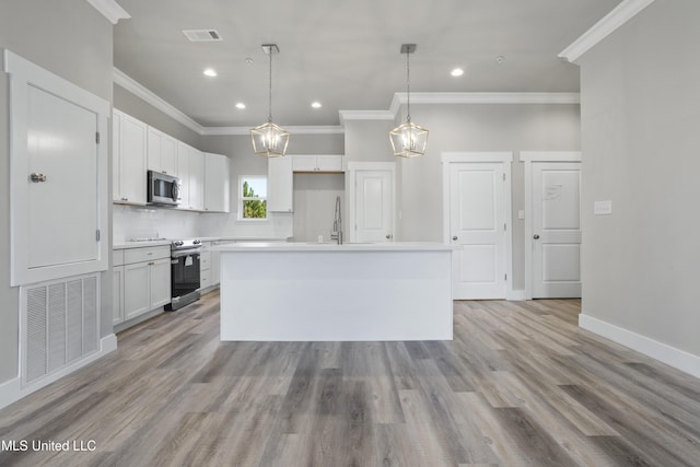 kitchen featuring appliances with stainless steel finishes, crown molding, white cabinets, recessed lighting, and an island with sink