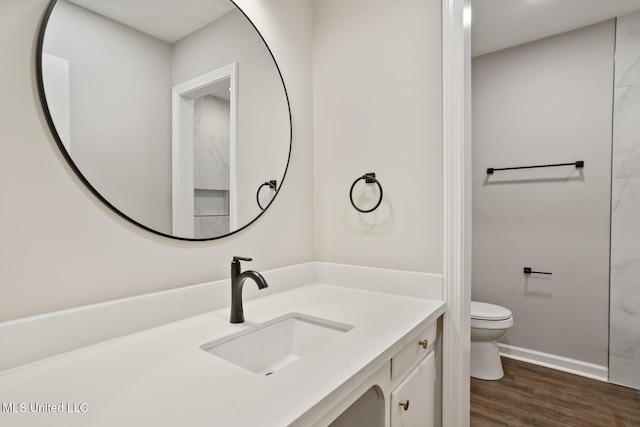 bathroom with wood-type flooring, toilet, and vanity