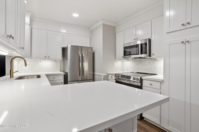 kitchen with appliances with stainless steel finishes, sink, and white cabinets