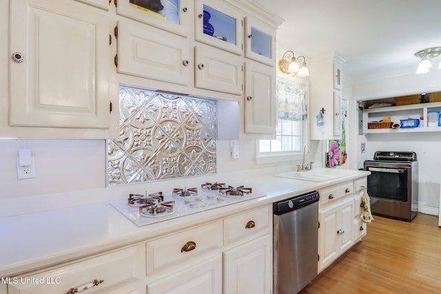 kitchen with a sink, white gas stovetop, stainless steel dishwasher, stove, and light countertops