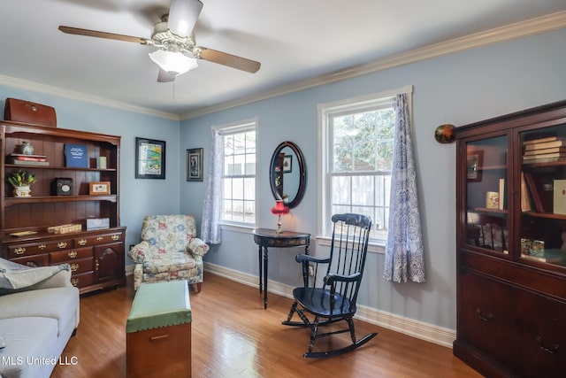 sitting room with a wealth of natural light, wood finished floors, and a ceiling fan