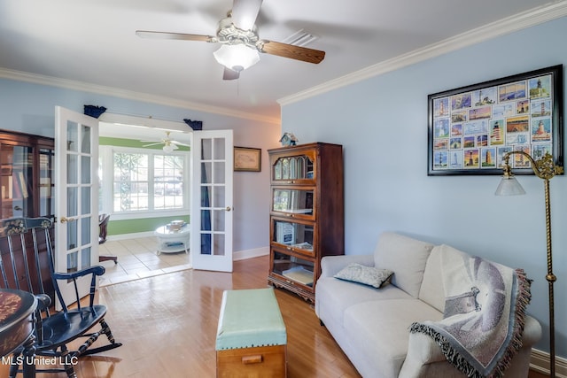 living area with a ceiling fan, french doors, baseboards, ornamental molding, and wood finished floors