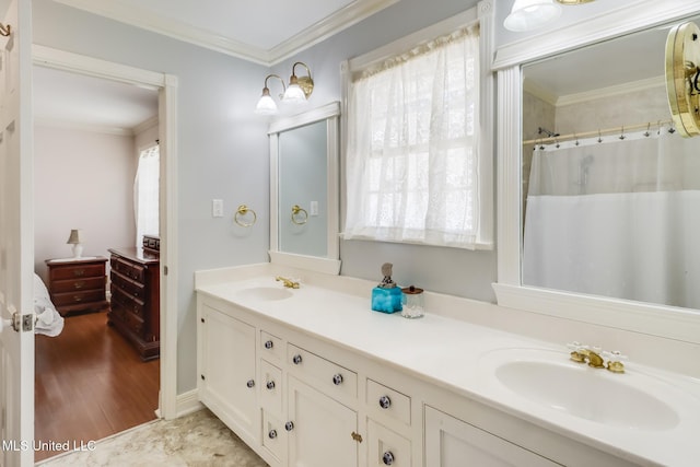 bathroom featuring a shower with curtain, ornamental molding, double vanity, and a sink