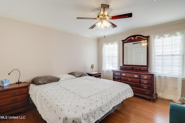 bedroom featuring ornamental molding, a ceiling fan, and wood finished floors