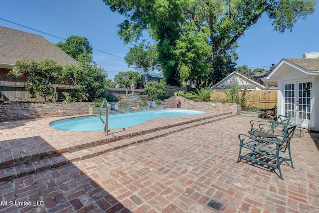 view of pool with a patio area, french doors, a fenced in pool, and a fenced backyard