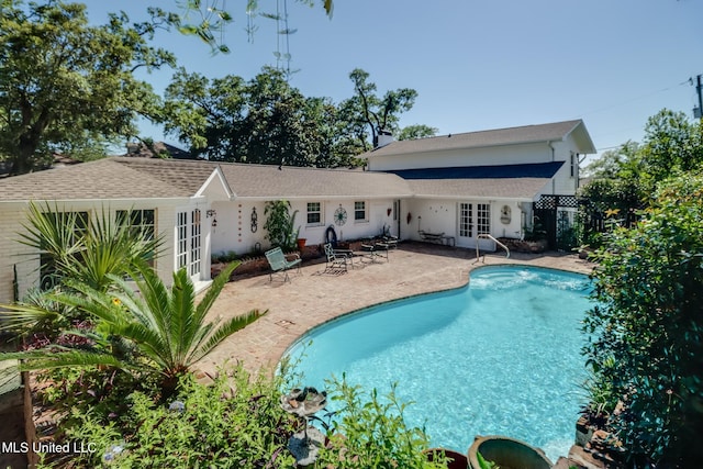 back of house with an outdoor pool, a patio, and french doors