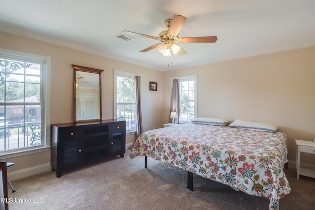 bedroom featuring baseboards, visible vents, crown molding, and carpet