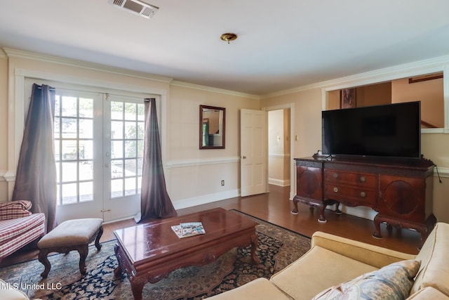 living room featuring crown molding, visible vents, and wood finished floors