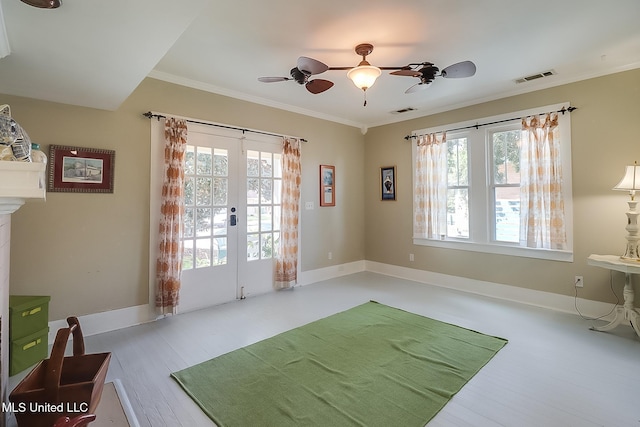 exercise area with french doors, a healthy amount of sunlight, crown molding, and hardwood / wood-style floors