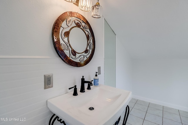 bathroom with lofted ceiling, sink, and tile patterned floors