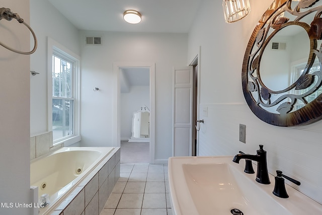 bathroom with tile patterned flooring, sink, and a relaxing tiled tub