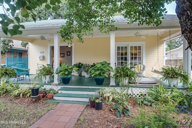 view of exterior entry with ceiling fan and a porch