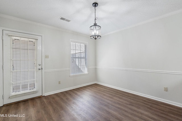 unfurnished dining area featuring crown molding, dark wood-type flooring, a textured ceiling, and an inviting chandelier