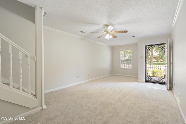 carpeted empty room with ceiling fan, ornamental molding, and a textured ceiling