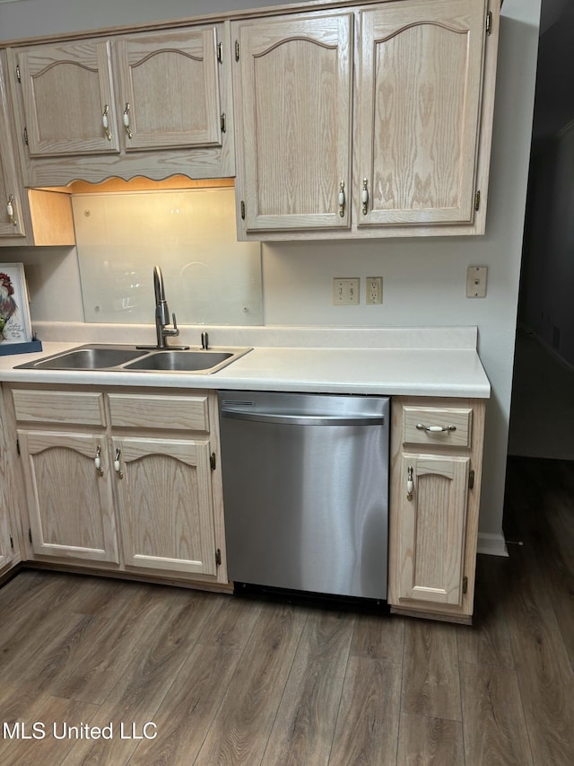 kitchen featuring stainless steel dishwasher, a sink, light brown cabinets, light countertops, and dark wood finished floors