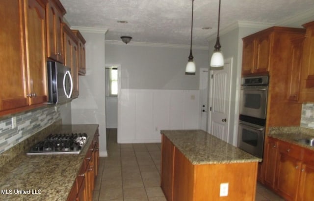 3542 Marcia Louise Dr, Southaven, MS 38672 - kitchen with stainless steel appliances, a center island, backsplash, dark stone countertops, and a wainscoted wall